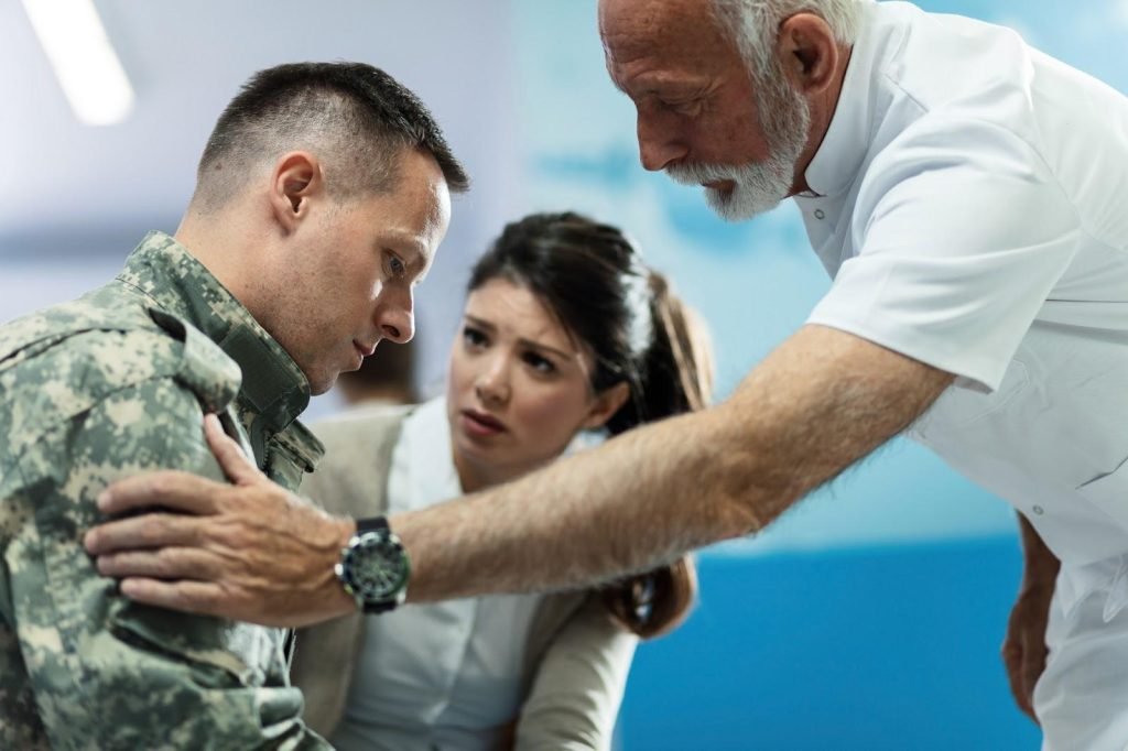 An older counselor comforts a young soldier and his wife during a counseling session. Counseling in divorce can have many benefits.