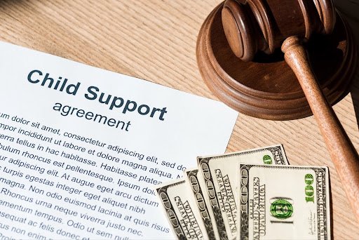 Money, a gavel, and child support papers, answering, “How Is Child Support Calculated?”