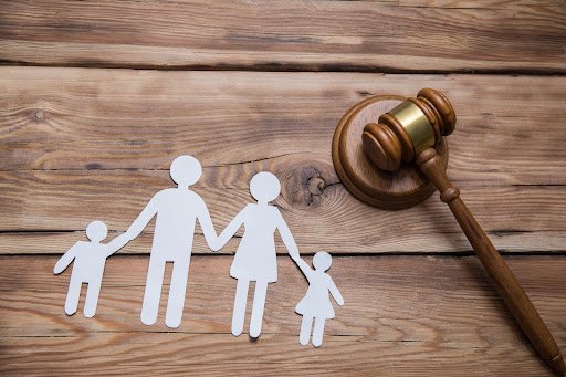 A gavel and paper cutouts of family and children. Navigating the child’s best interest standard can be complicated.
